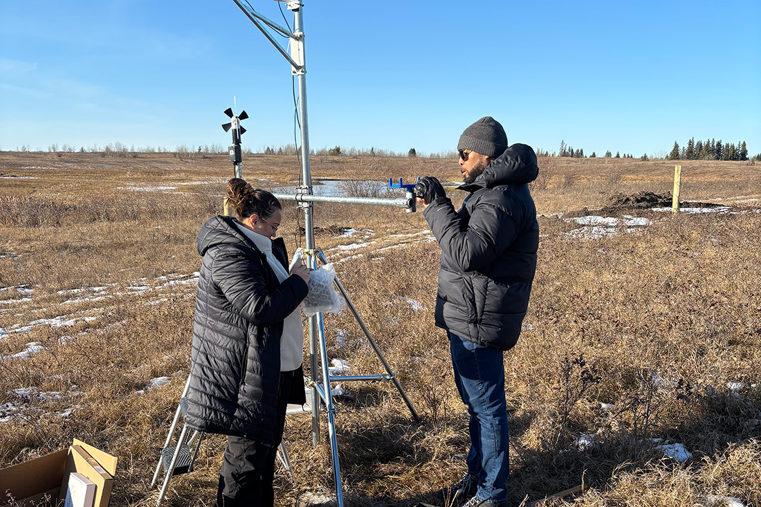 Krishna Kolen, PhD candidate, and Hayden Billingy, MSc student, install a weather station in the Mistawasis Nêhiyawak community to help monitor weather conditions leading up to and during air quality events. (Credit: Corinne Schuster-Wallace)  
